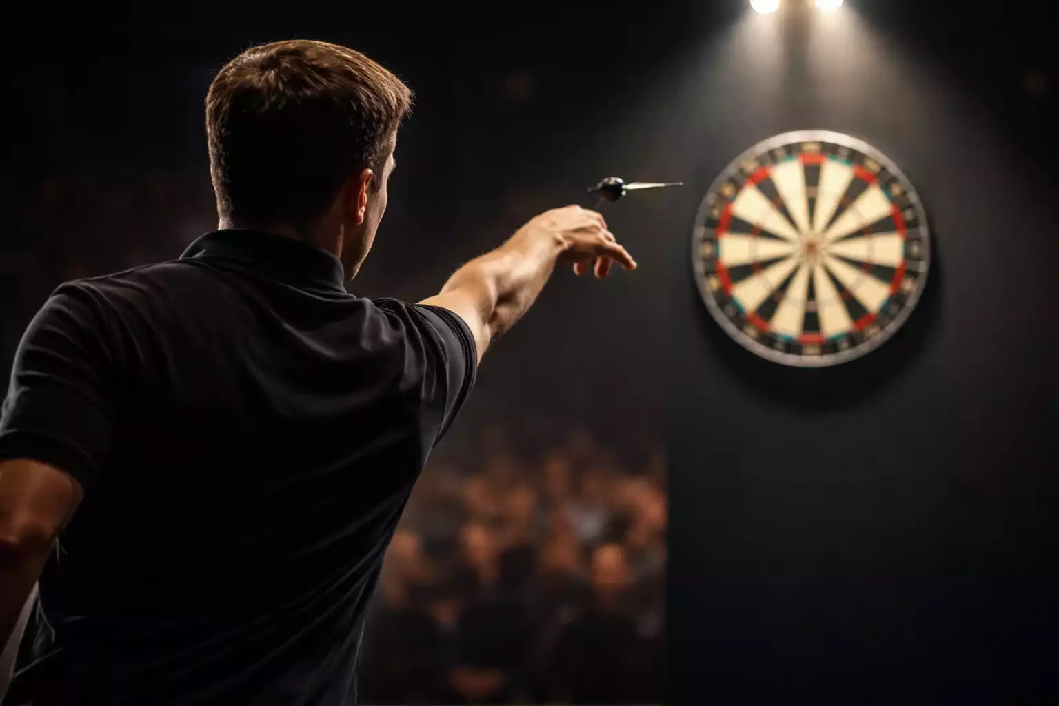 Darts-Wetten-Strategien — Spieler wirft Dartpfeil auf beleuchteter Turnierbühne